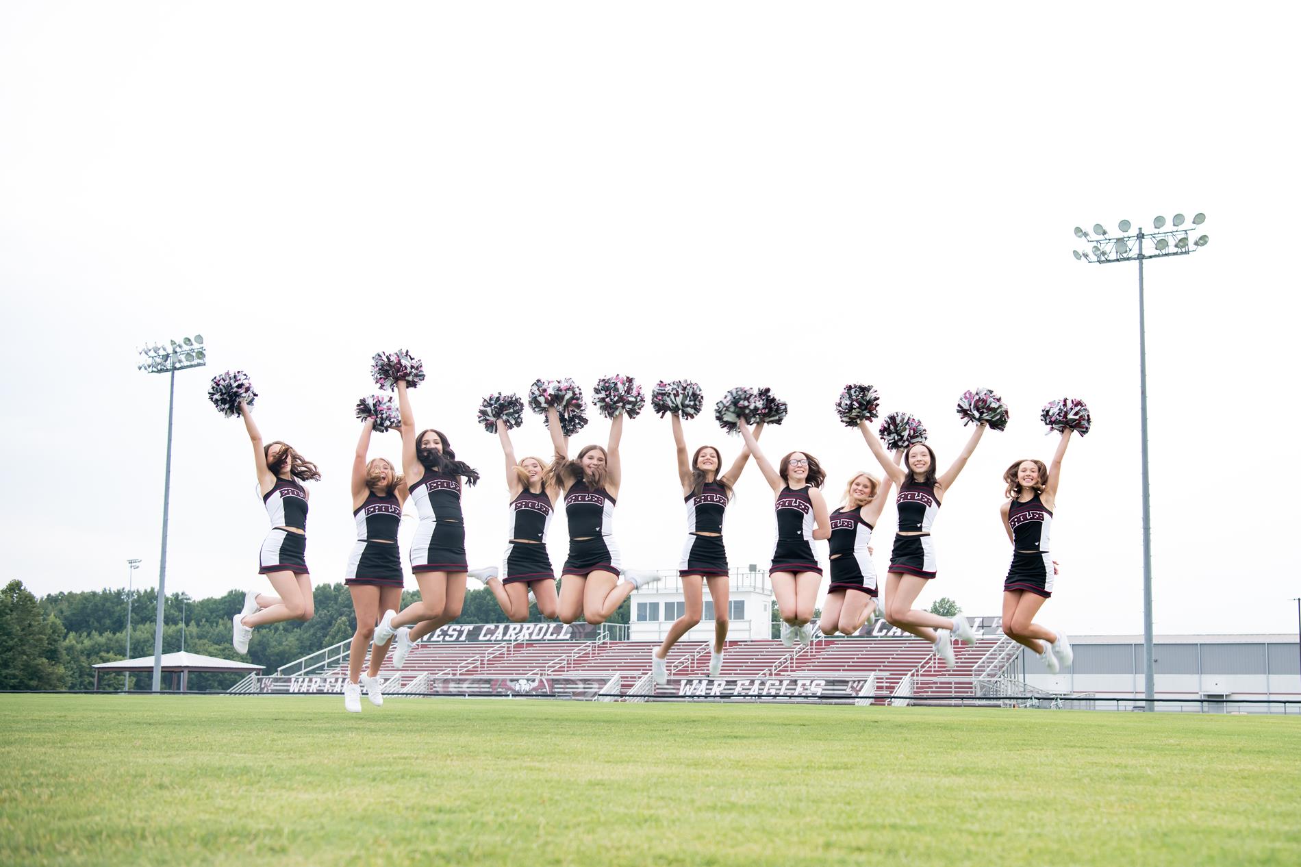 HS cheerleaders jumping on football field