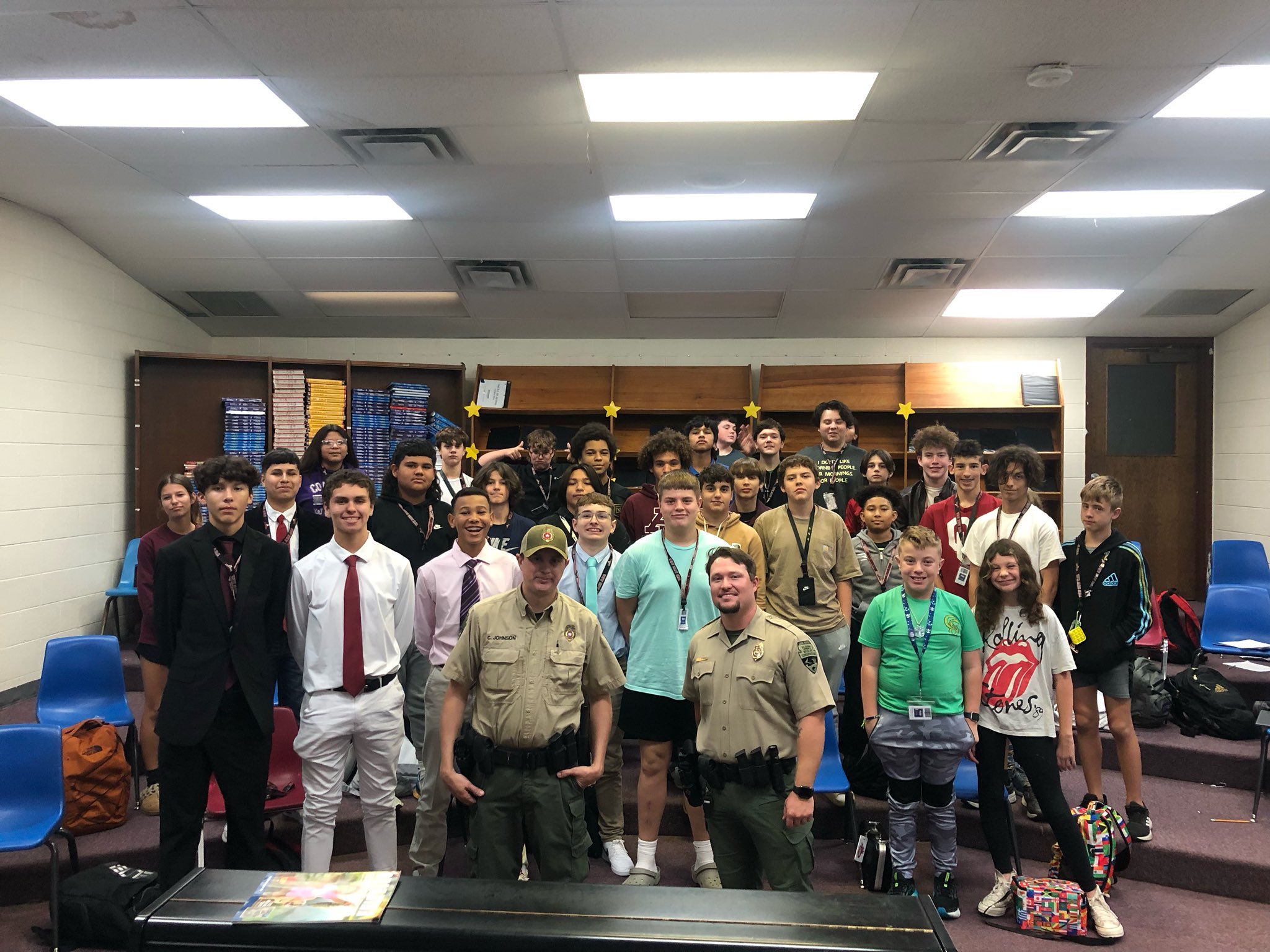 Ada Junior High Outdoor Living Class poses with two game wardens that visited the class.