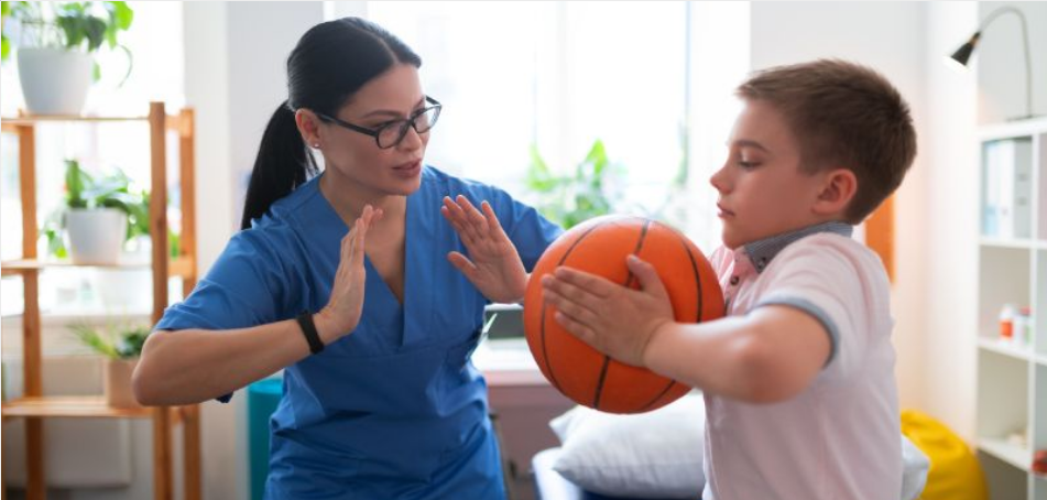therapist with child holding basketball