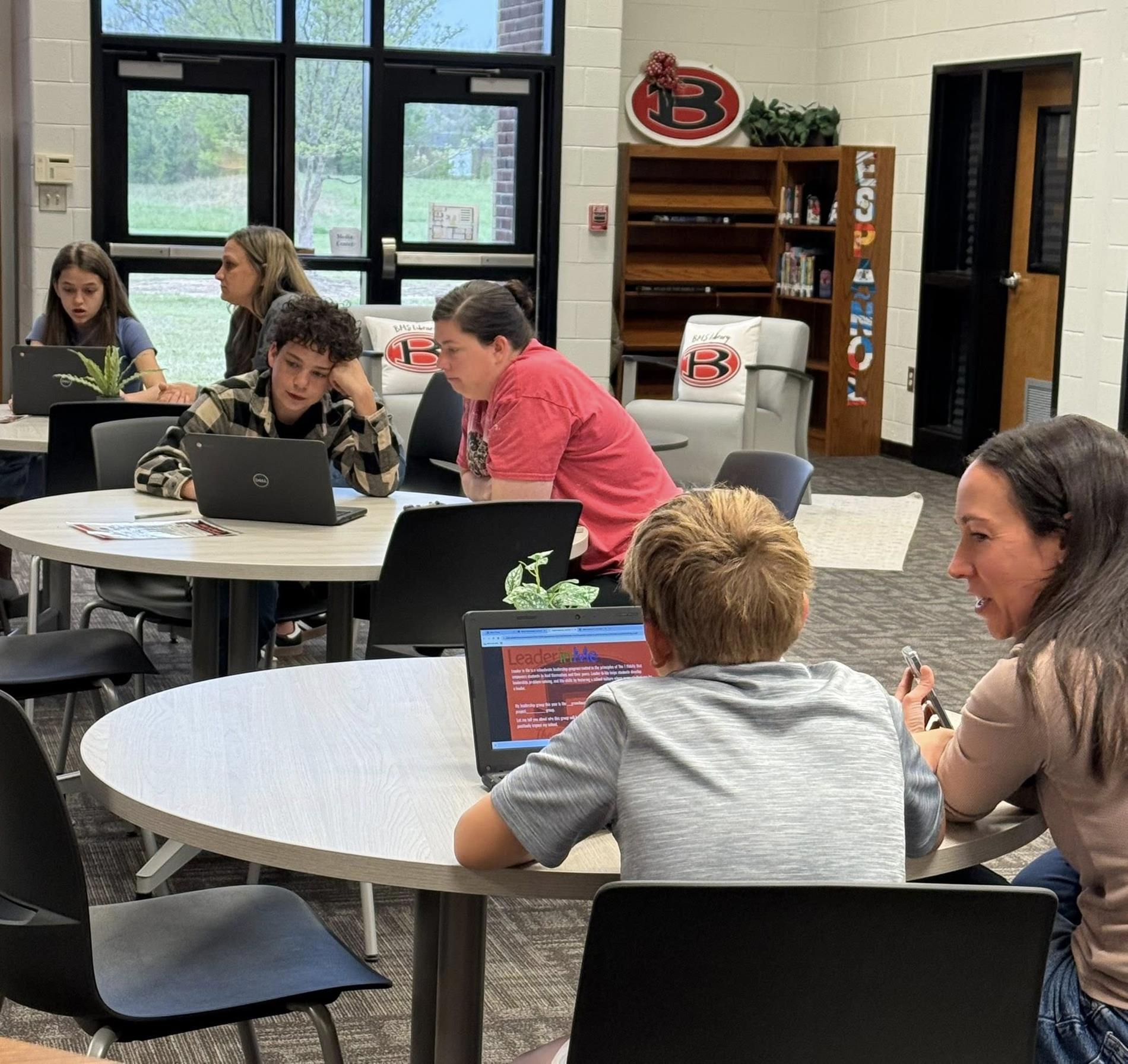 Students with their parents in the library participating in student-led conferences