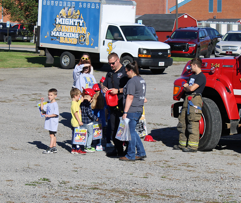 Students see the equipment on the trucks and get their own fire helmet