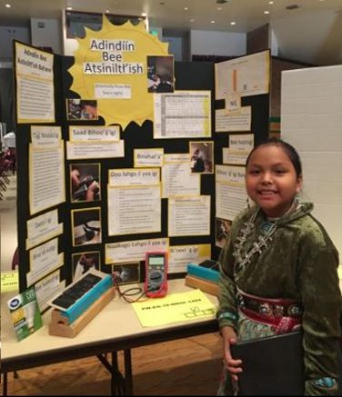 Student presenting a science-fair board.