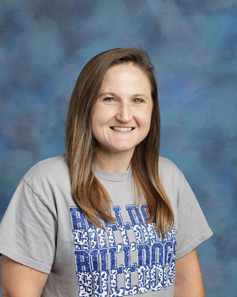 teacher smiling against blue background