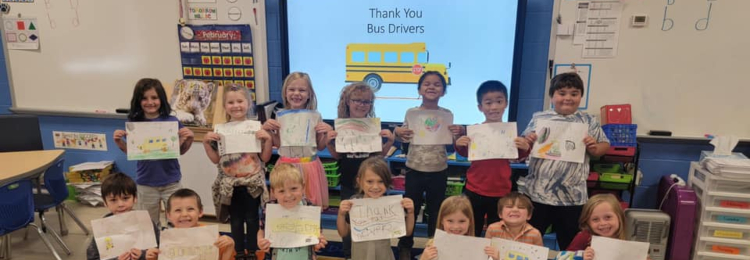students holding thank you cards for bus drivers