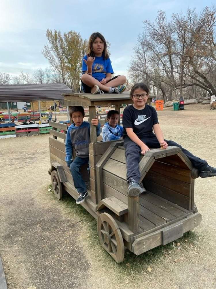 4 students in the wooden play truck