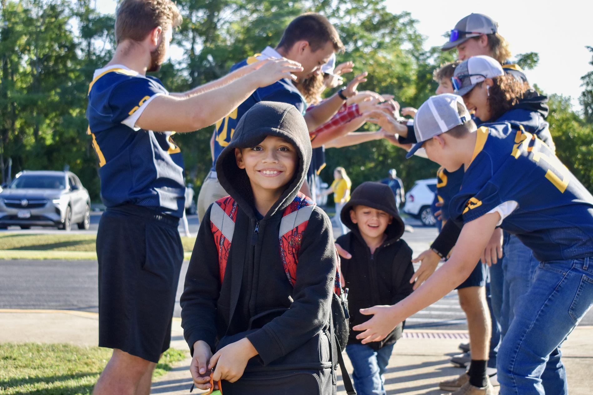 football team greets students