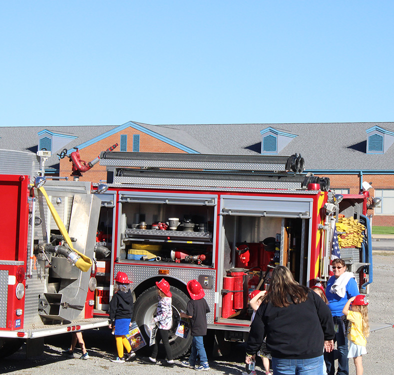 Students see the equipment on the trucks and get their own fire helmet