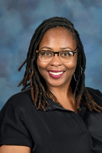 Teacher smiling against a blue background