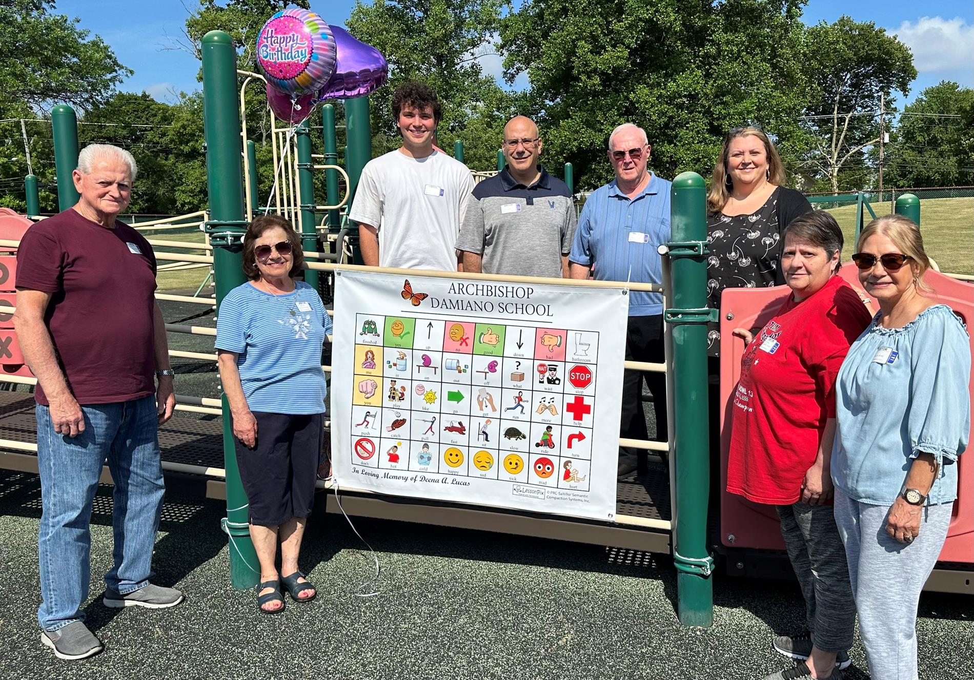 Deena's family with vinyl communication boards on playground