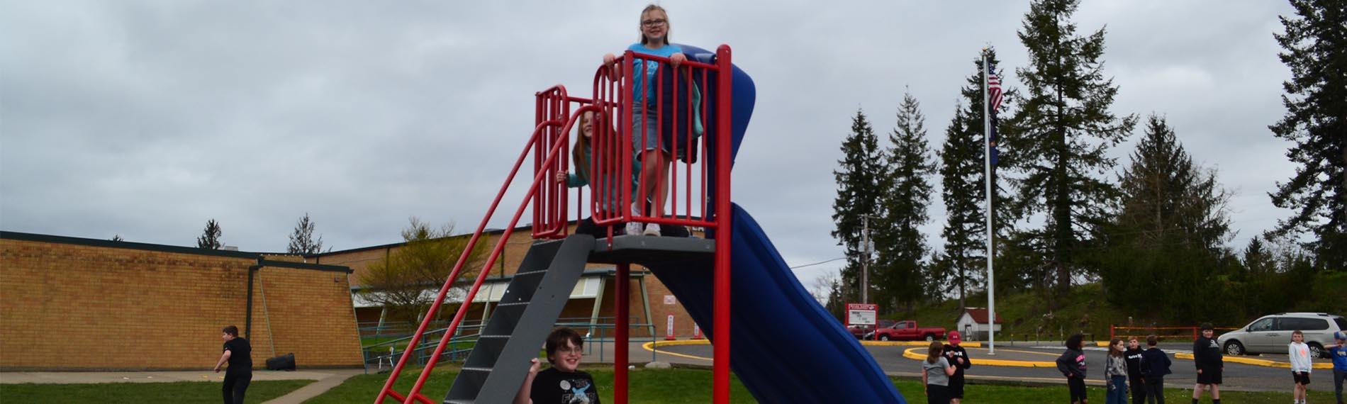 Elementary Students on the slide at recess