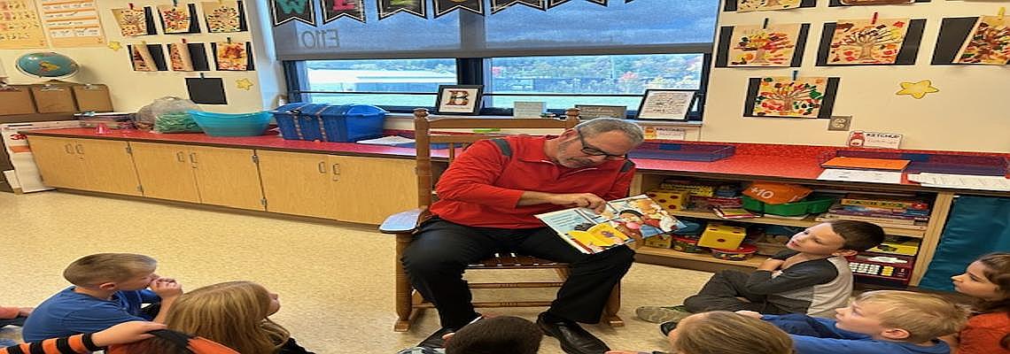 Mr. Turek reading a Halloween story to Mrs. Barota's first grade classroom