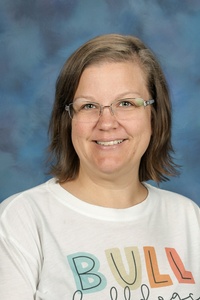 Teacher smiling against a blue background