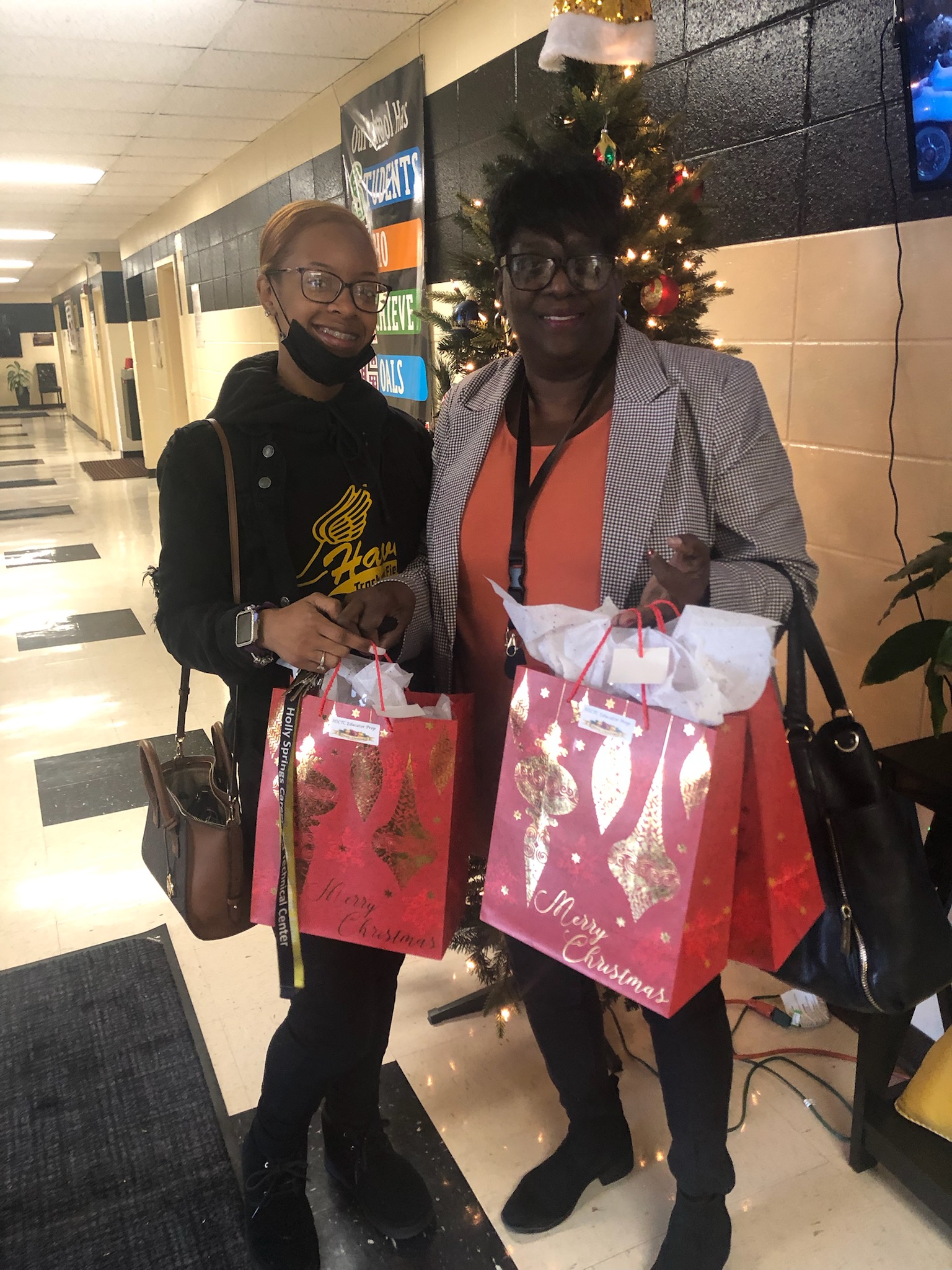 CTC Educator Prep  instructor Sadie Campbell and December Student of the Month Oriah Hampton prepare Yo deliver gifts to the Primary School students.  