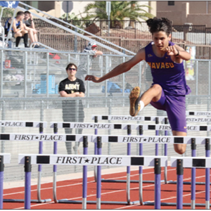 LHHS Track student jumps over hurdles during recent meet