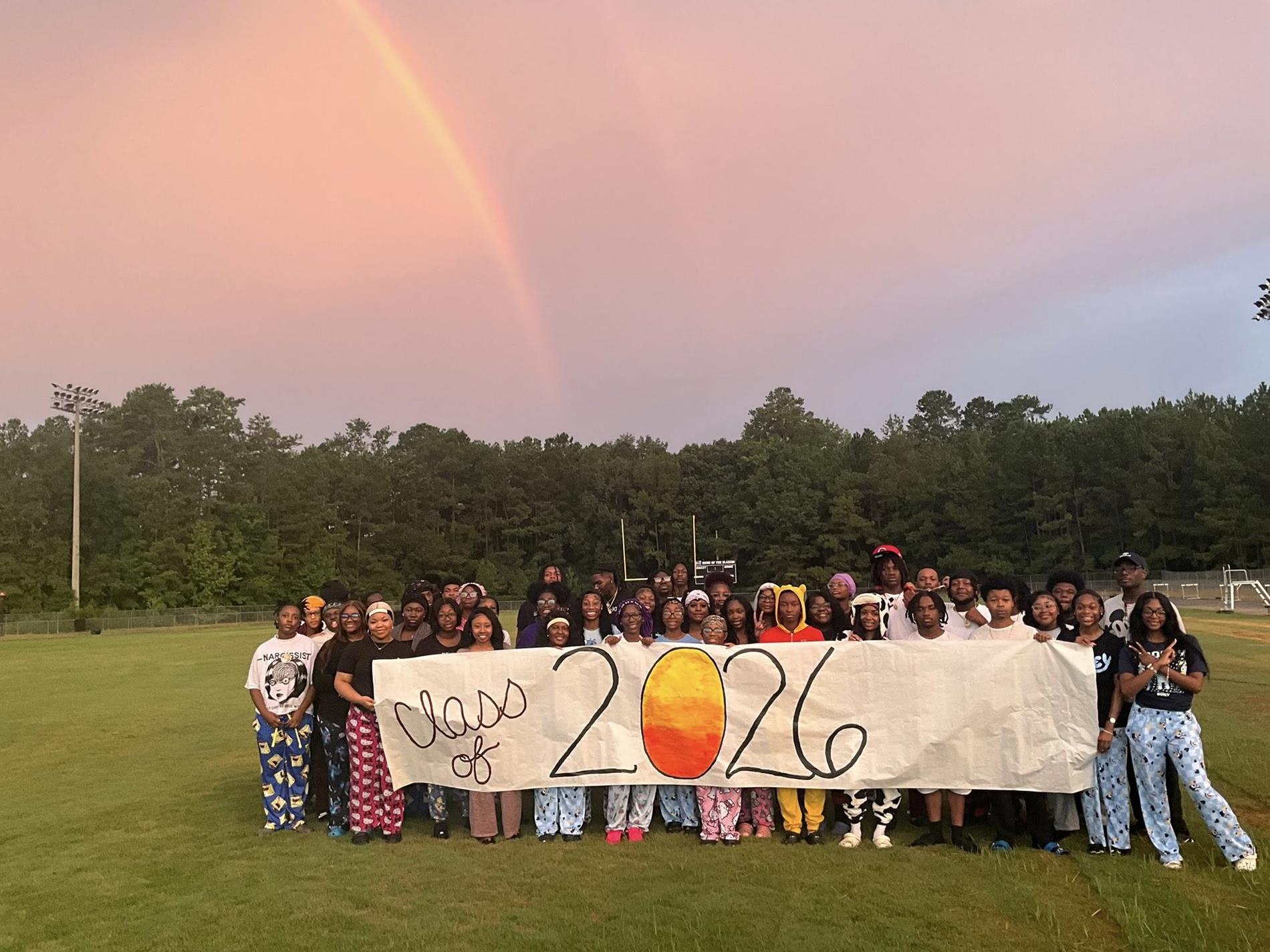 class of 2026 on banner with students standing behind it