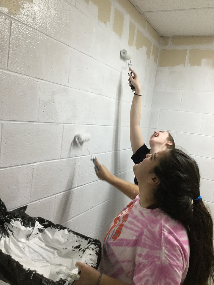 Students volunteering to help paint
