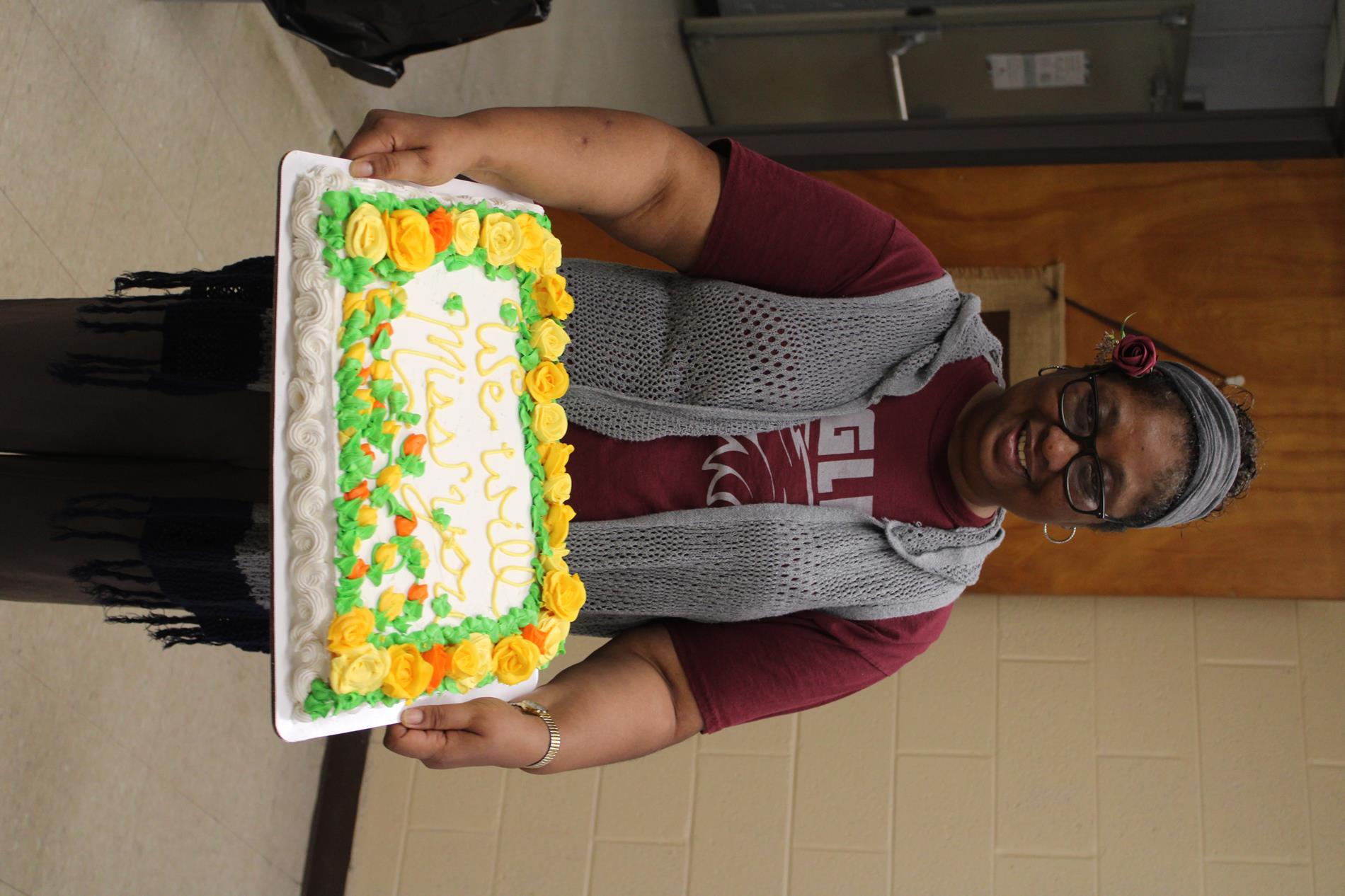 Mrs Ruby retires holding retirement cake