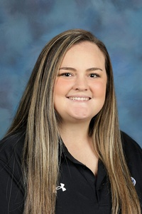 Teacher smiling against a blue background