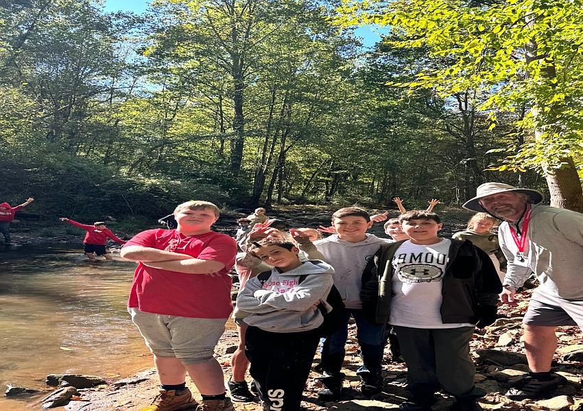 Mr. Strother poses with students at Dunbar Creek during the 6th grade trout stocking field trip