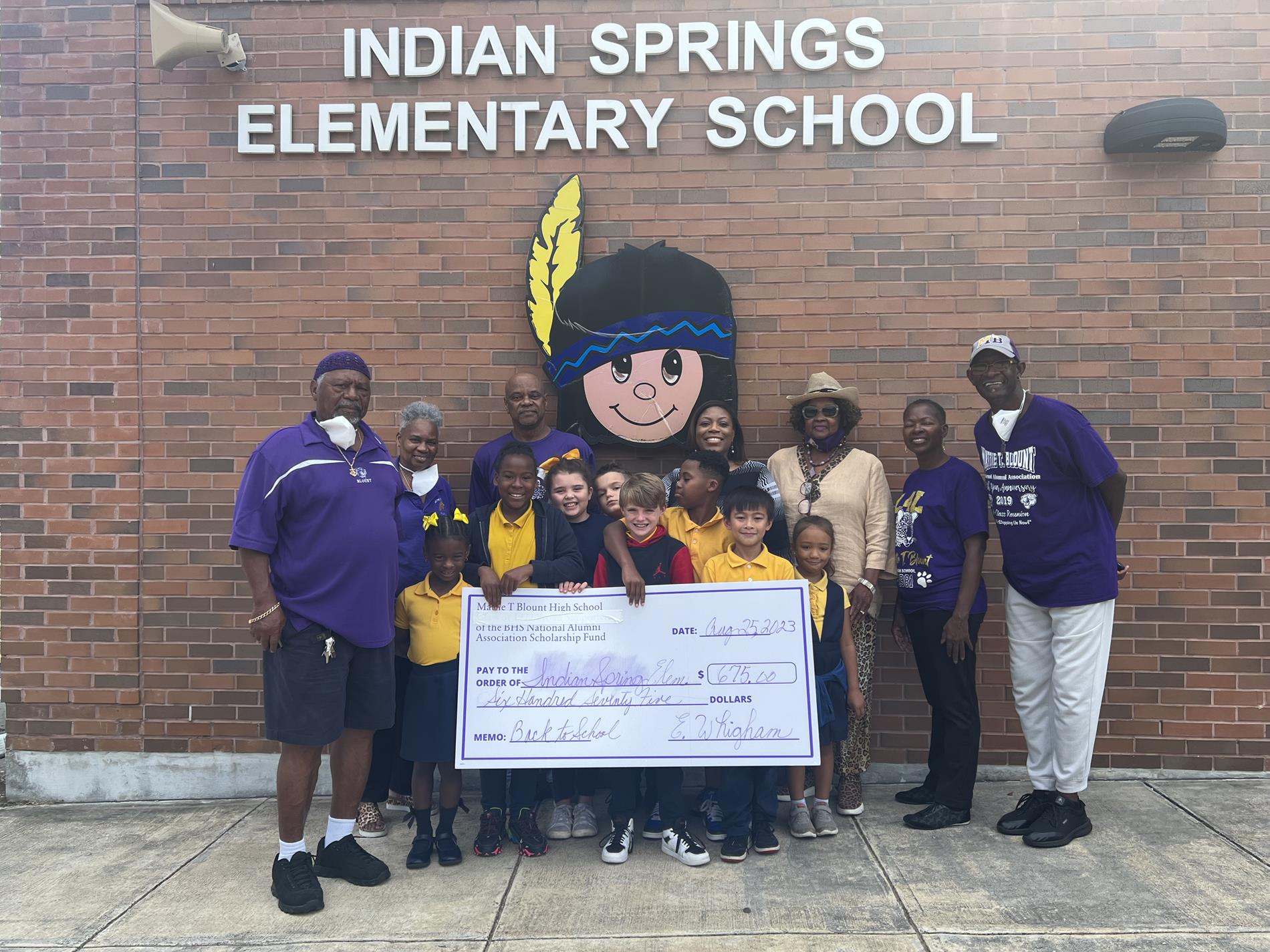 Alumni Association Members with principal and students holding donation check