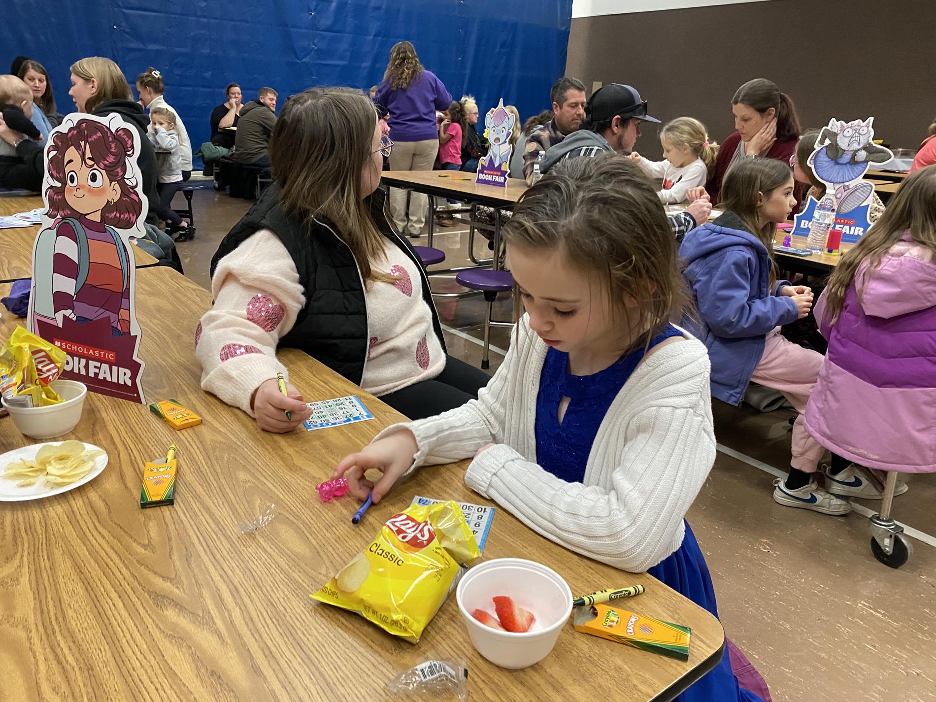 Young girl and Adult Female playing Bingo and eating snacks