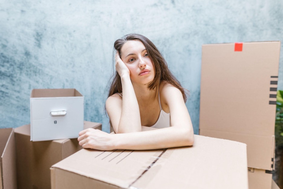 Teenage girl leaning on box in frustration