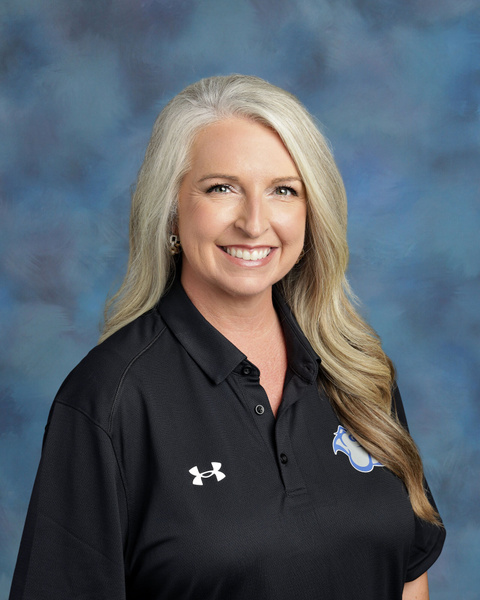 Teacher smiling against a blue background