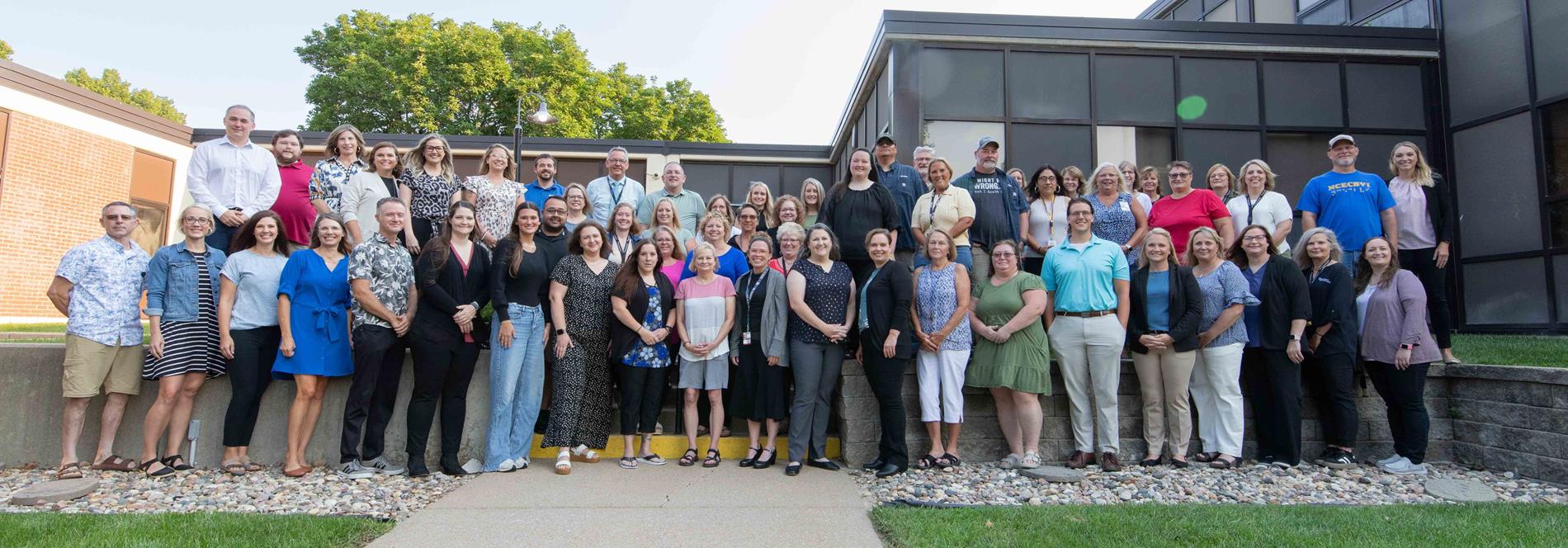 ESU 4 staff standing outside of a building prior to the start of school