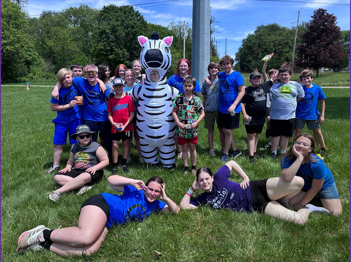 Field Day 2026 Students posing for a picture with teacher in a zebra costume