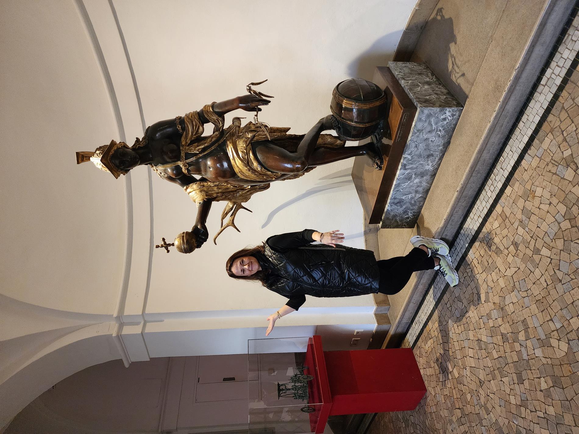 Mrs. Rogers posing with a statue of Diana, goddess of the hunt