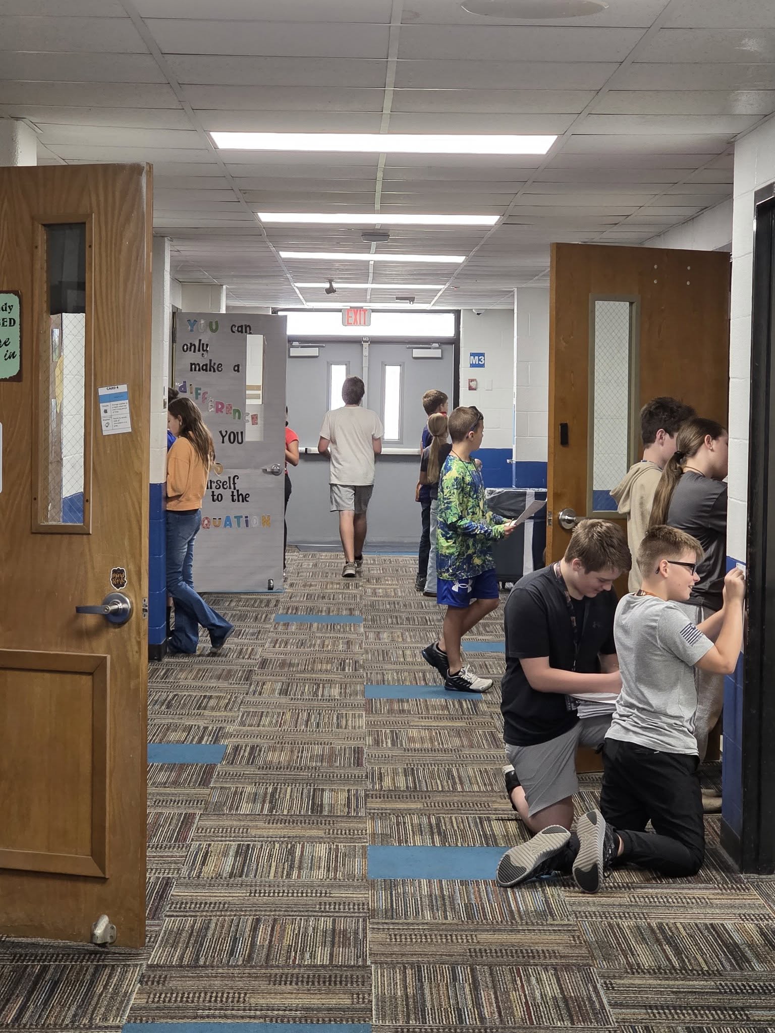 Middle school students working assignments in the hall
