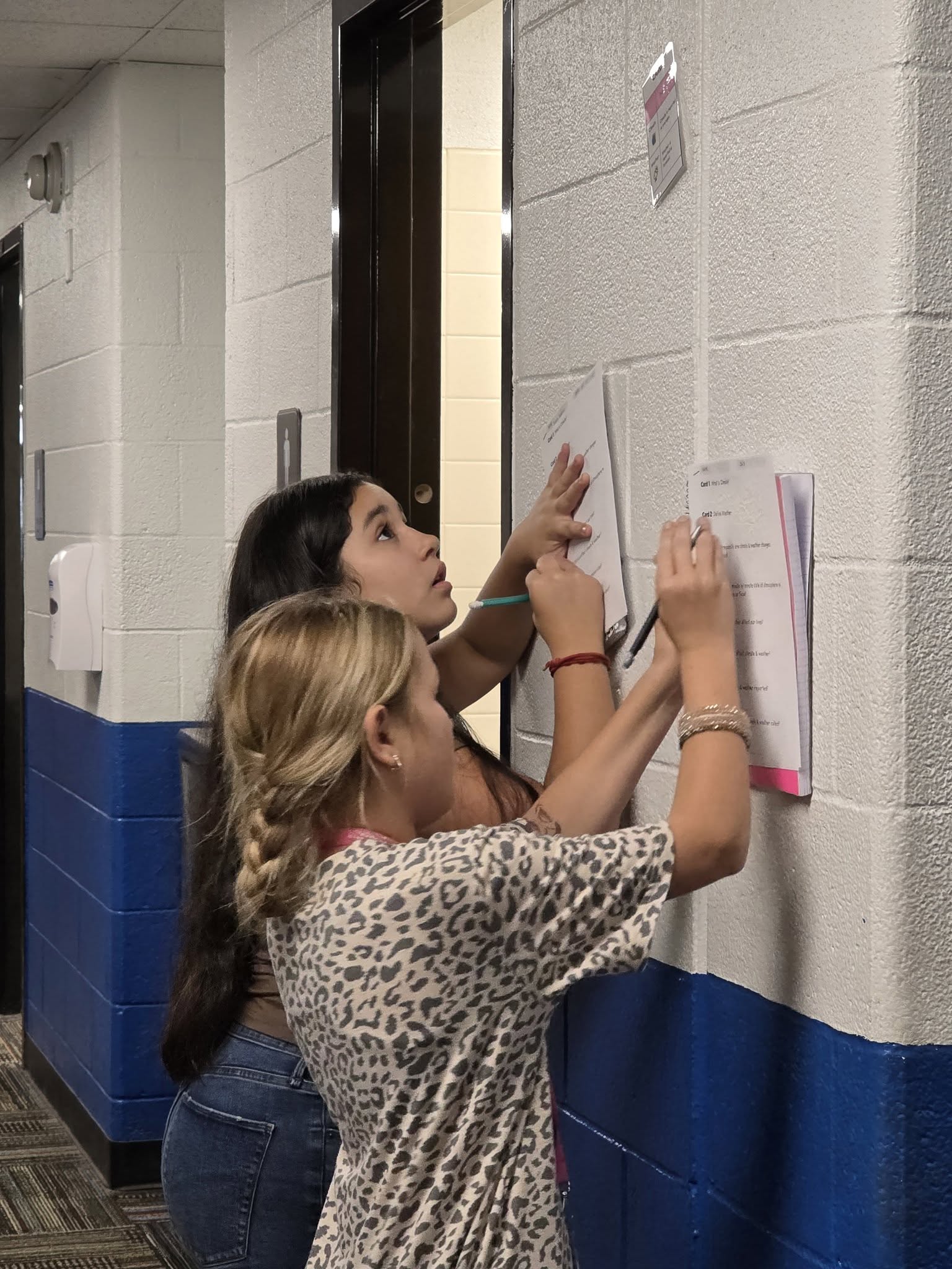 Middle school students working assignments in the hall
