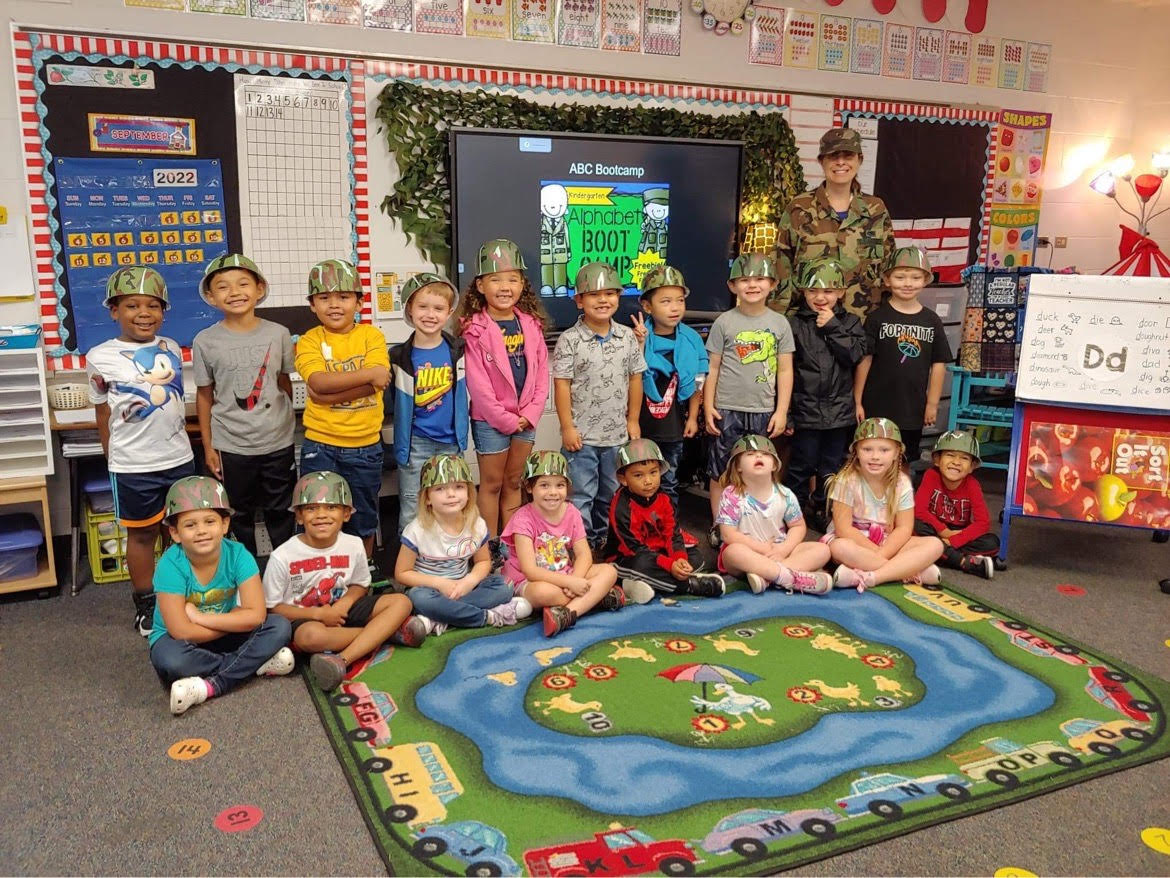 Mrs. Fulton's students wearing army helmets in a group photo as they begin alphabet boot camp