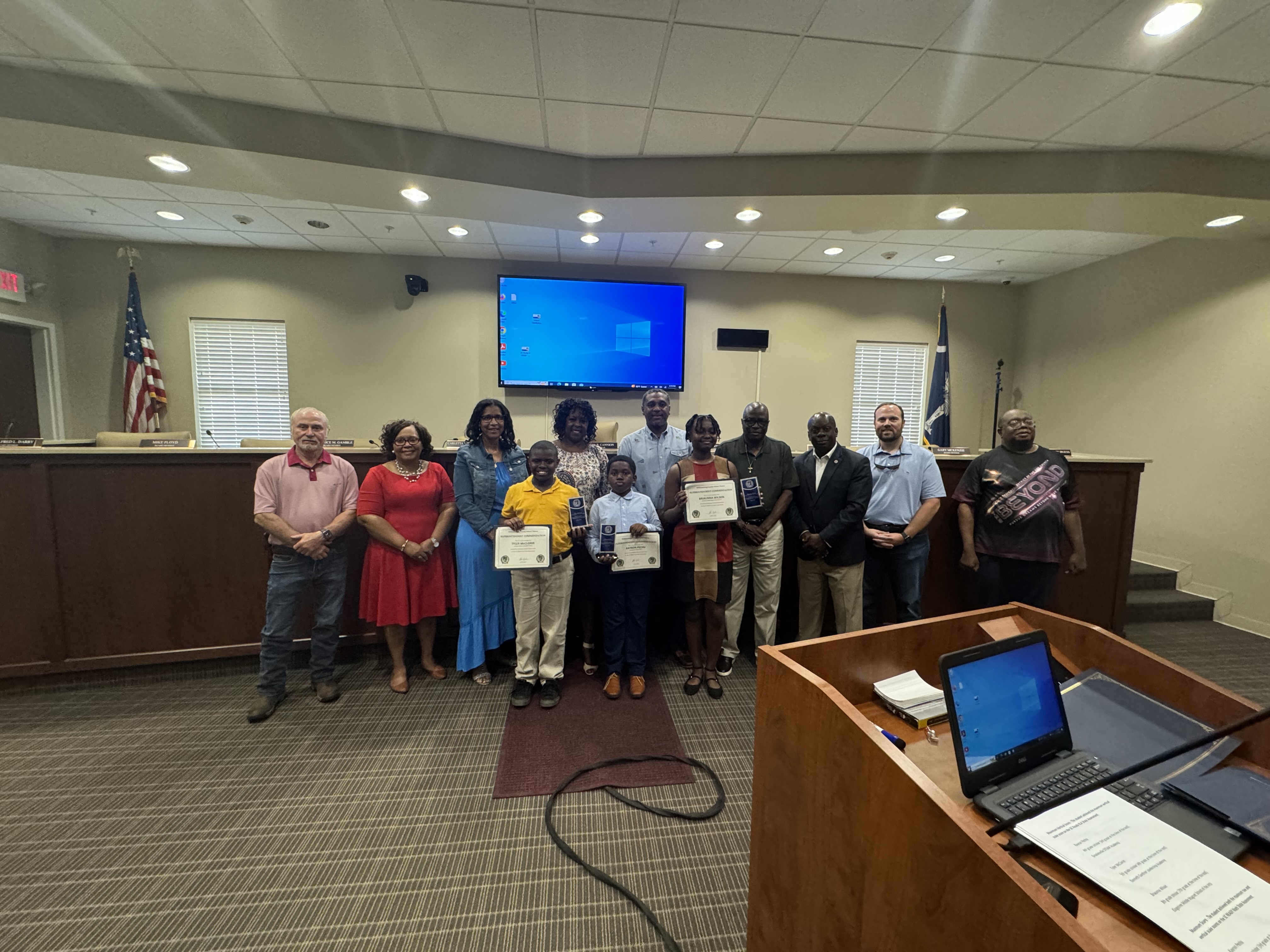 Students being recognized for their academic achievement pictured along with school board members 