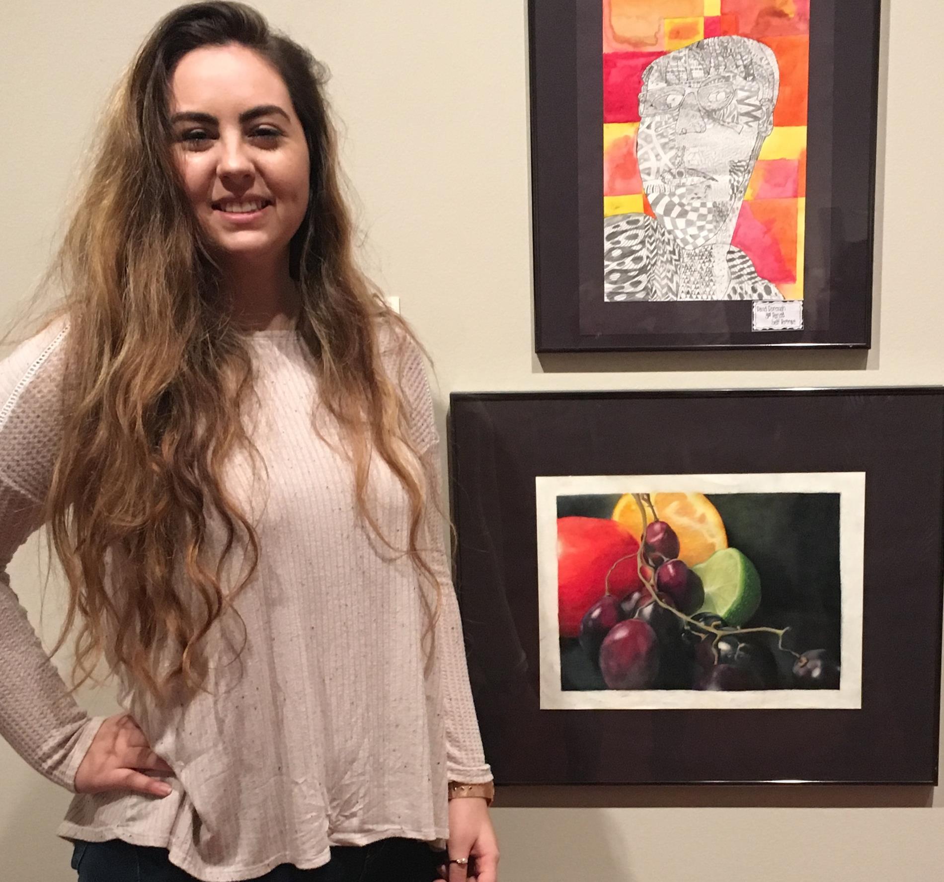 Student posing with her artwork