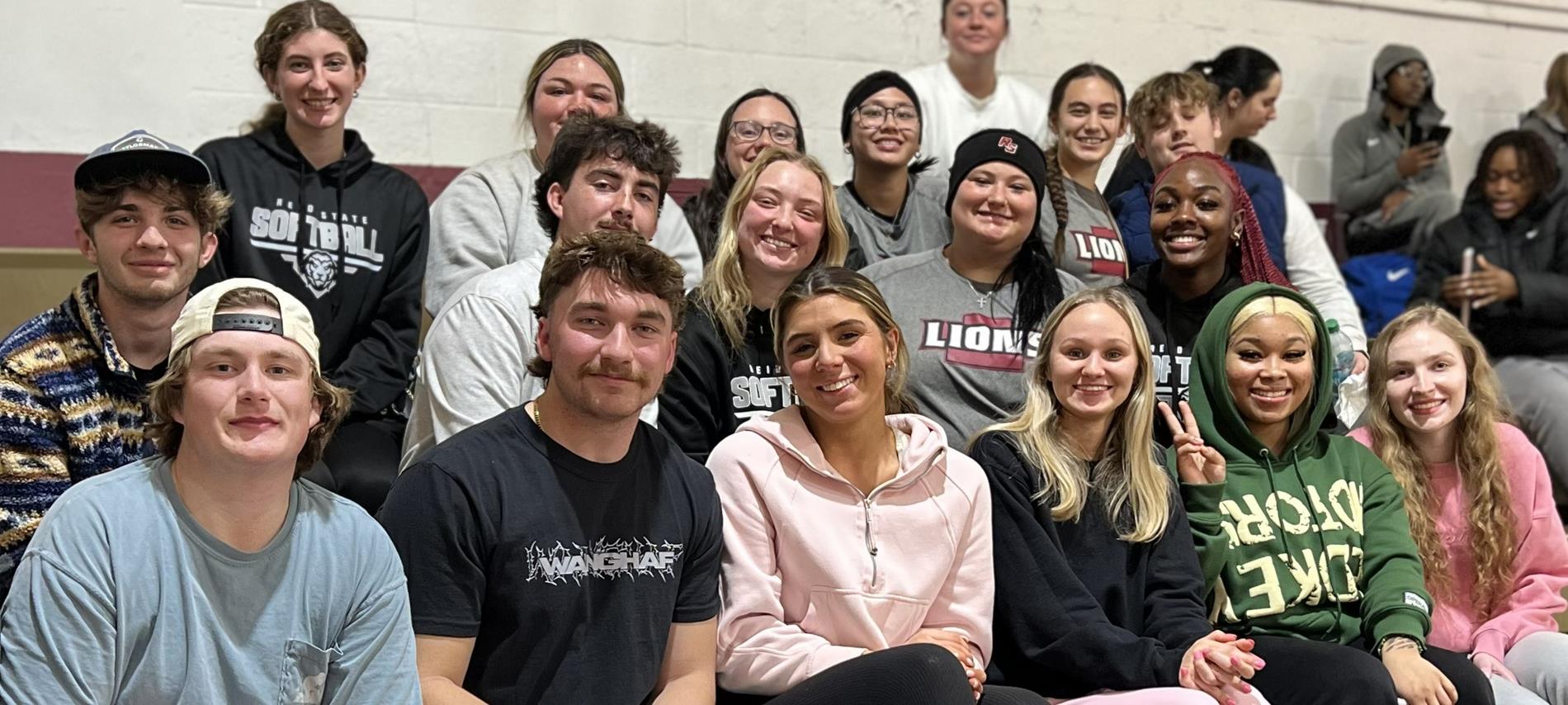 Students sitting in stands at a basketball game