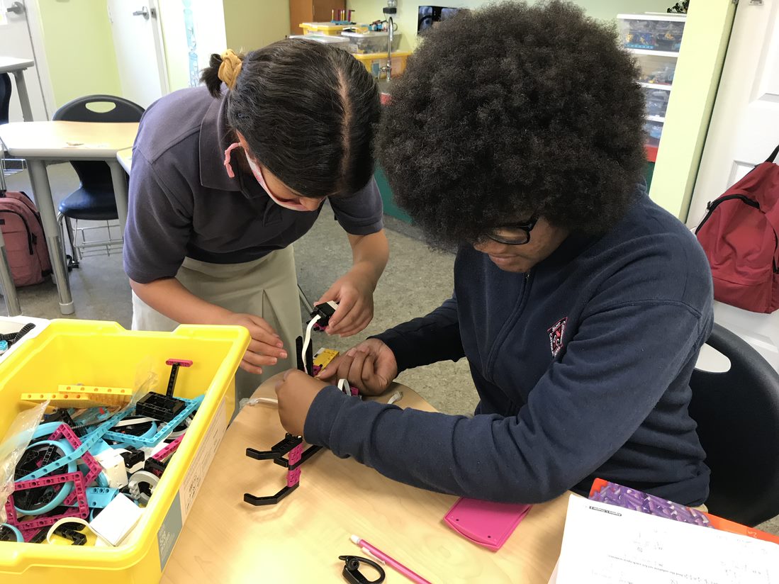 Ta'Mya and Madison work together to build a robotic arm.