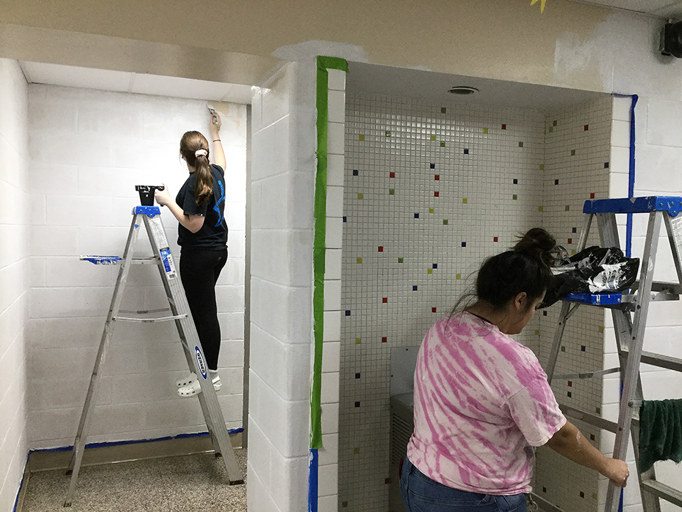 Students volunteering to help paint