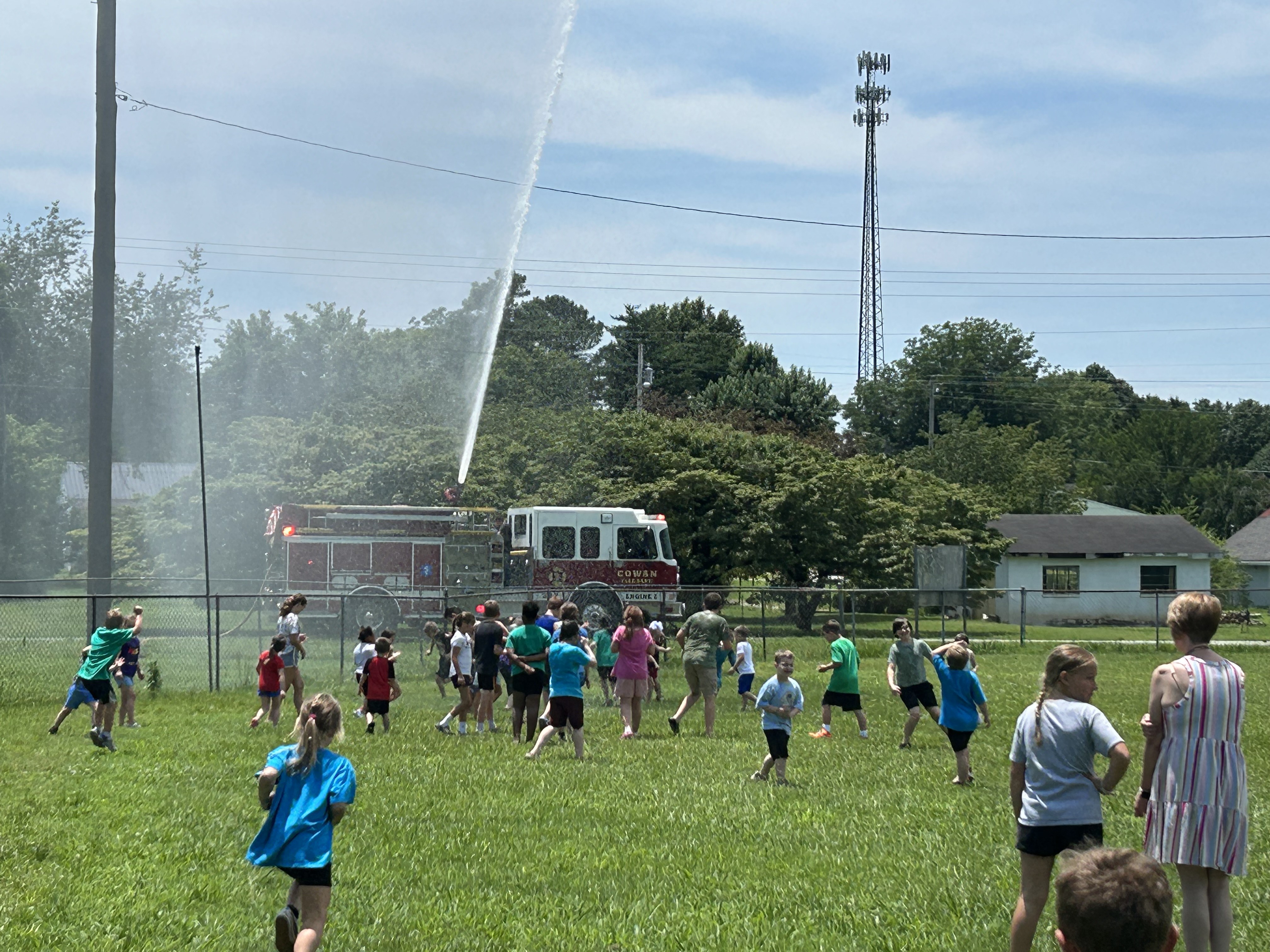 kids playing in the water from a fire truck