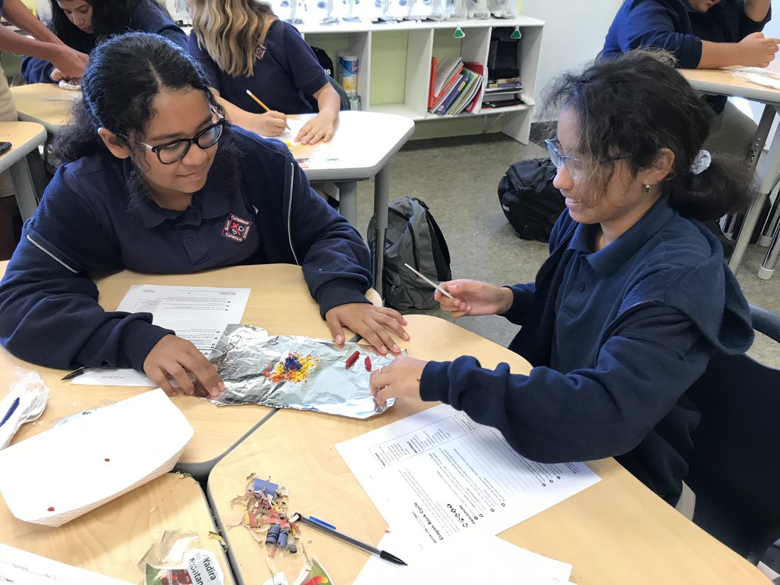 Lilianna and Caridad use grated crayon to learn about compaction and how sedimentary rock is formed.