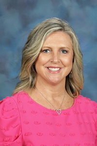 Teacher smiling against a blue background