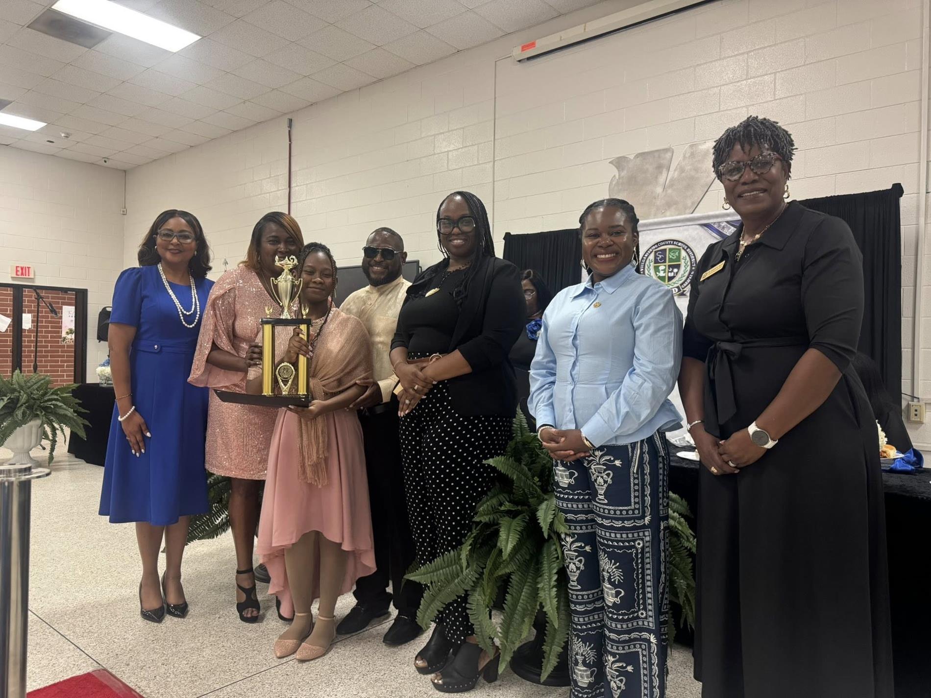 people standing together. one is receiving an award 
