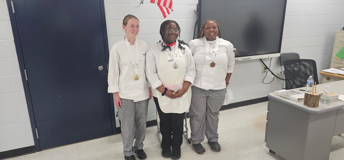 three girls in culinary uniforms 