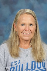 Teacher smiling against a blue background
