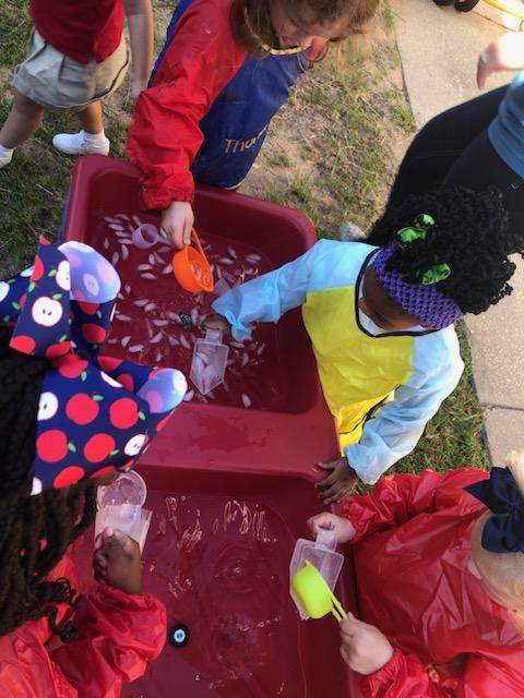 The preschoolers played with ice in the water to cool off,