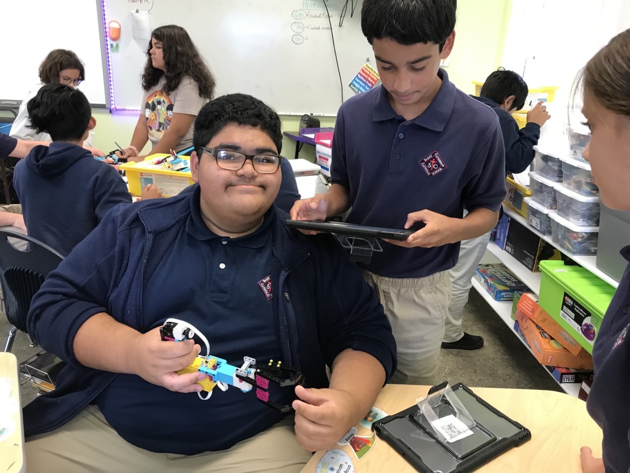 Michael uses peer teaching to show Juan how to code.