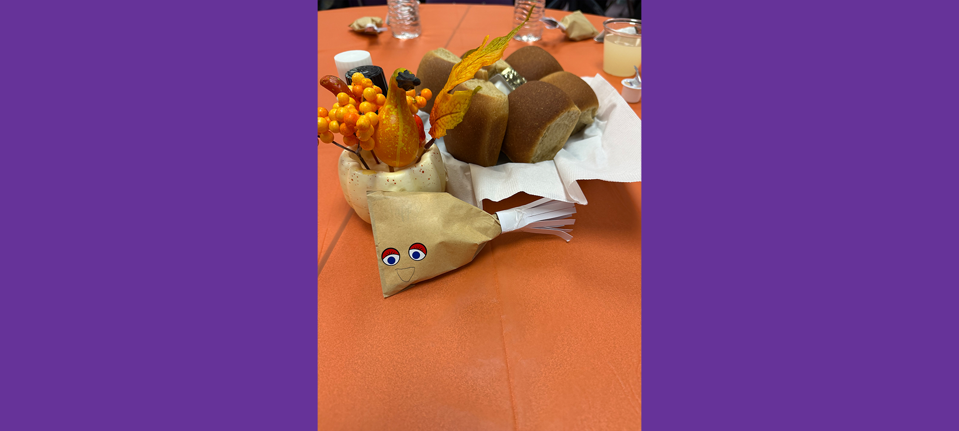 Thanksgiving Community Dinner center pieces on table, bread, drumbstick, and decorations