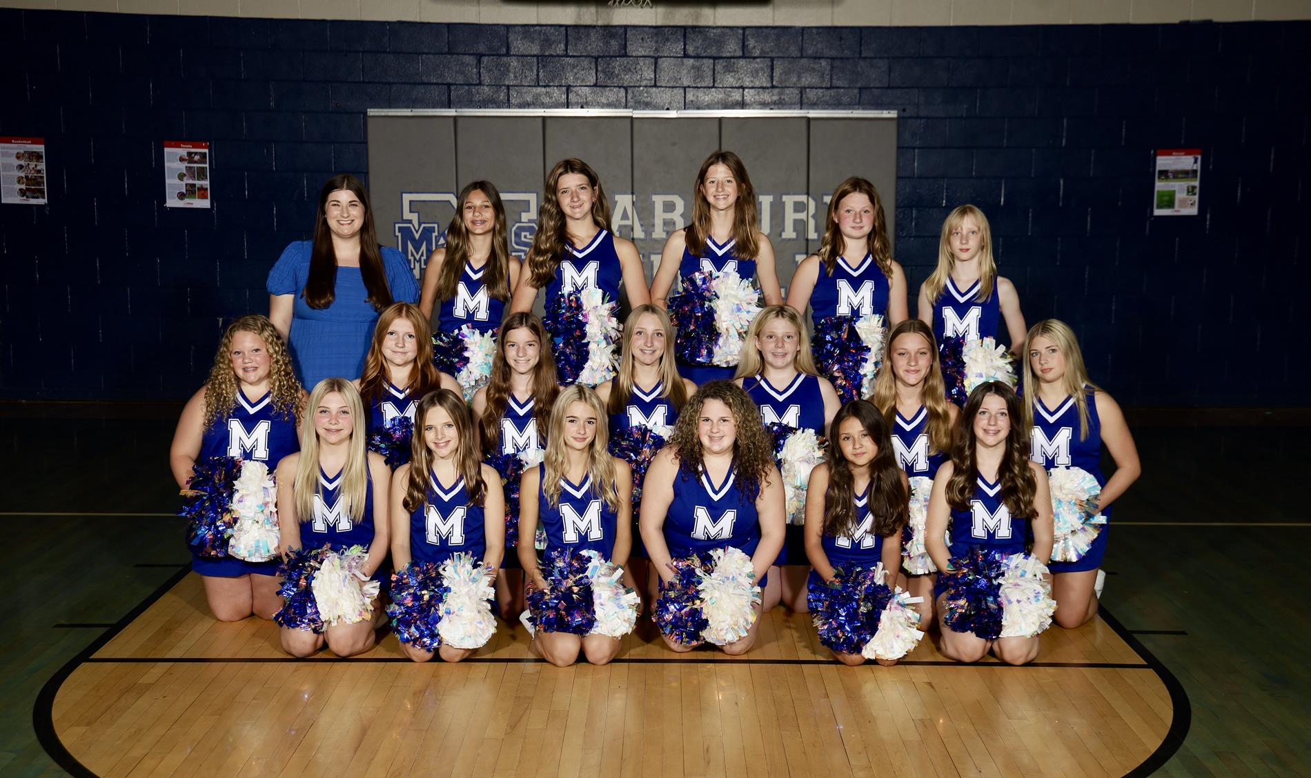 MMS cheerleading team posing together in matching uniforms, smiling for a group photo.