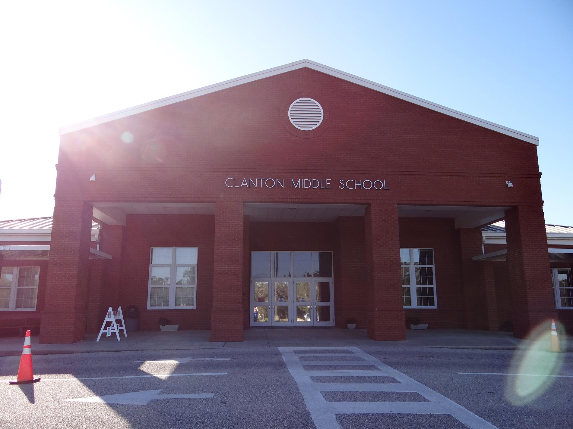 Front Entrance of Clanton Middle School - A red-brick school building with four tall brick columns framing the front doors