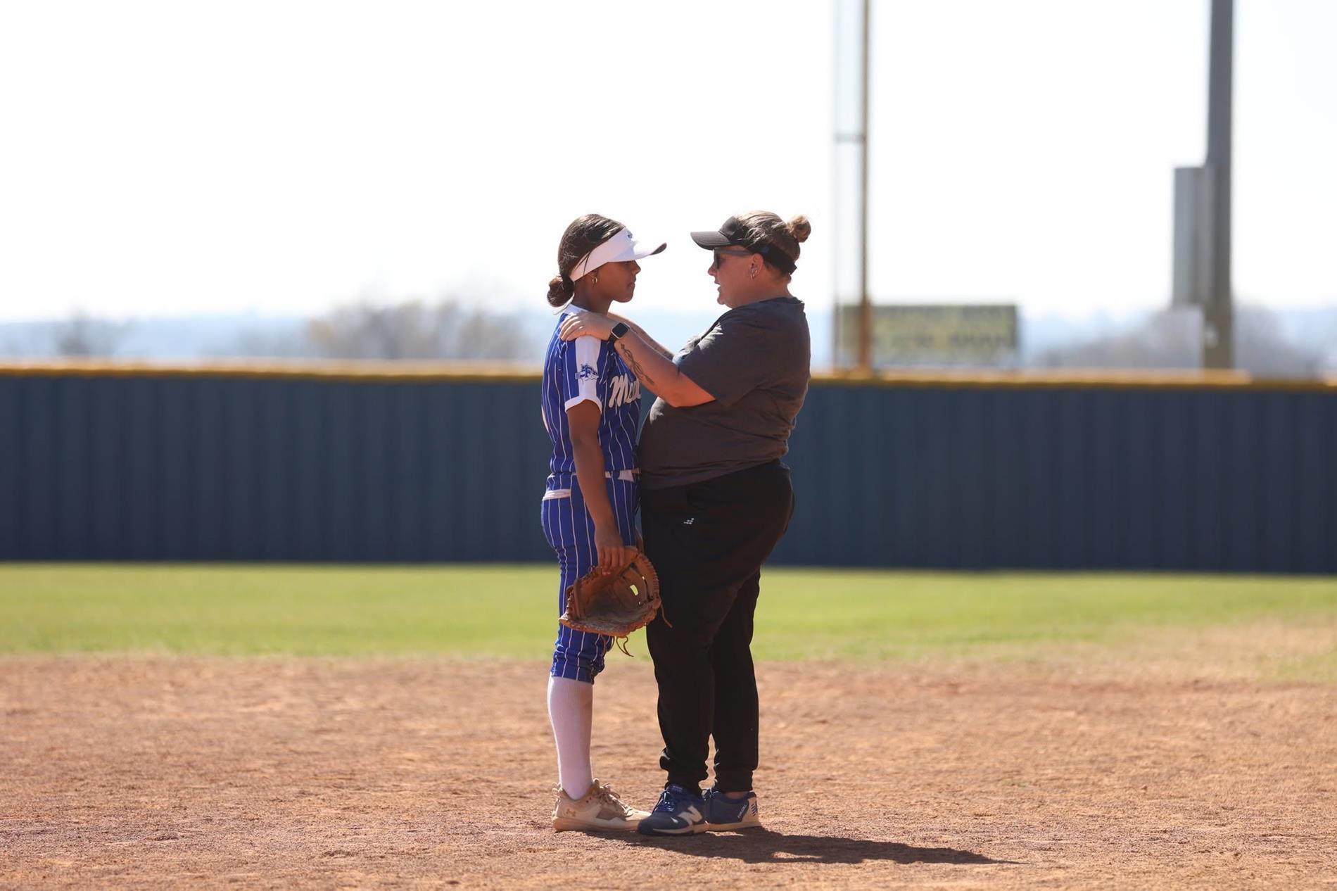 coach martin at softball game coaching a player